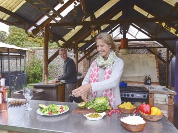 Couple marié qui prépare à manger dans sa cuisine extérieure