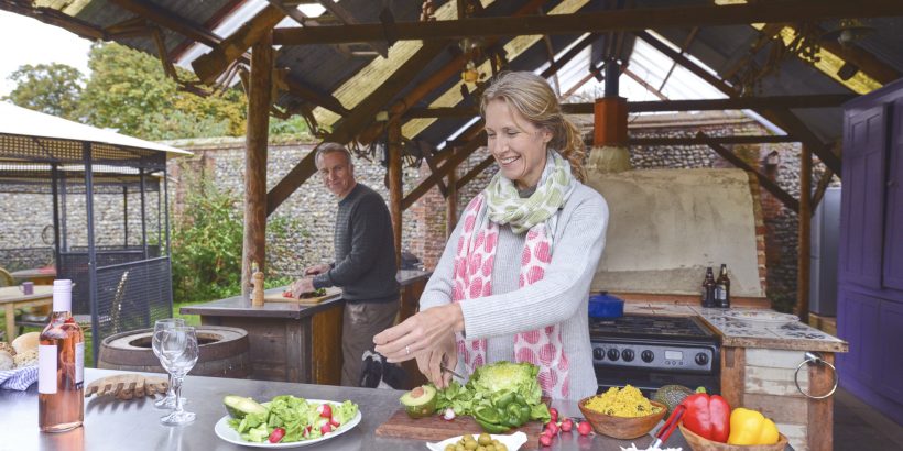 Couple marié qui prépare à manger dans sa cuisine extérieure