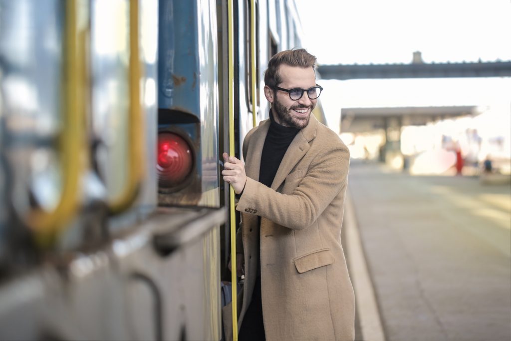 homme portant des lunettes un manteau beige long et un pull noir à col roulé