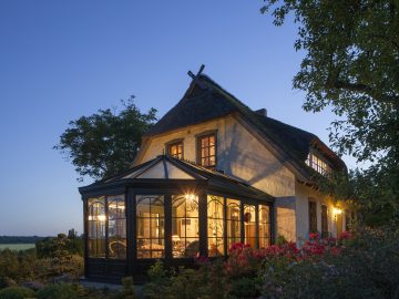 Photo de nuit d'une maison avec véranda