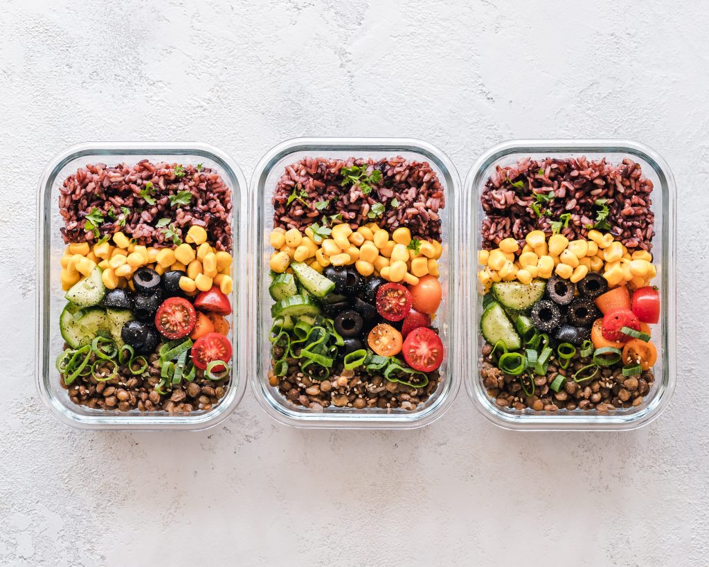 3 boites en verre avec salade préparée avec riz pois chiches maïs concombre olive tomates