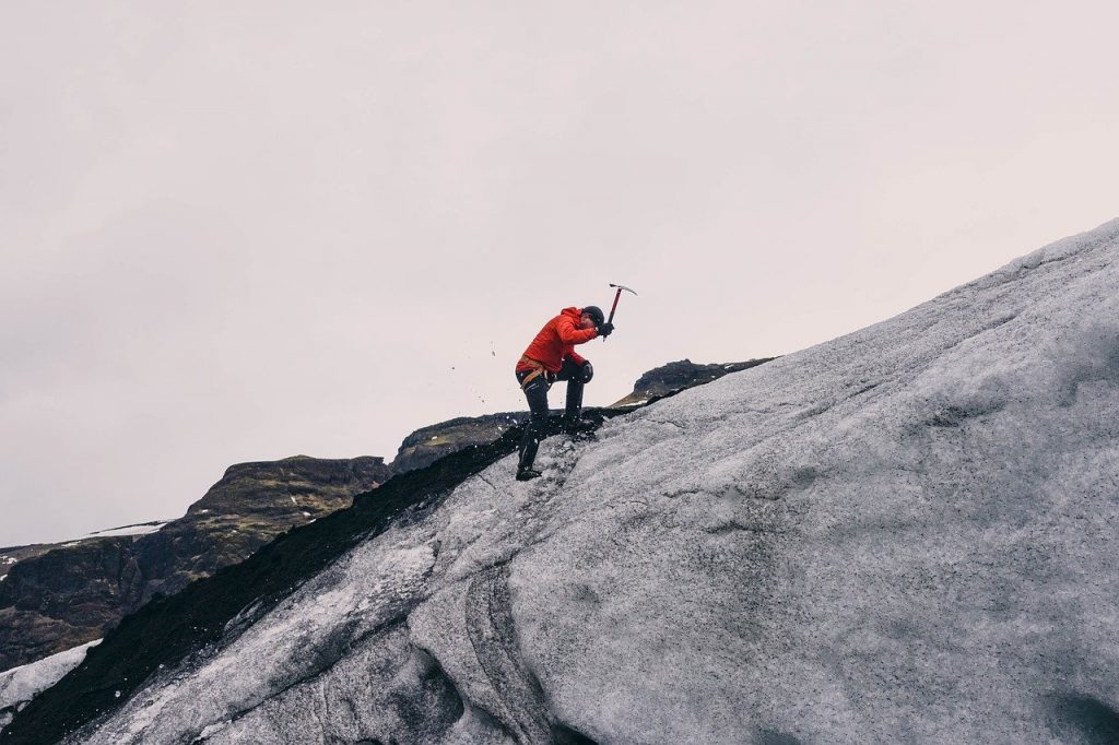 personne faisant de l'alpinisme sur la glace avec un piolet