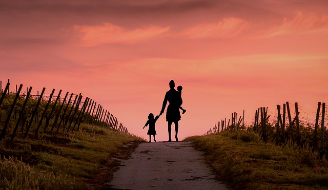 femme et enfant au bout d'un chemin avec couchée de soleil